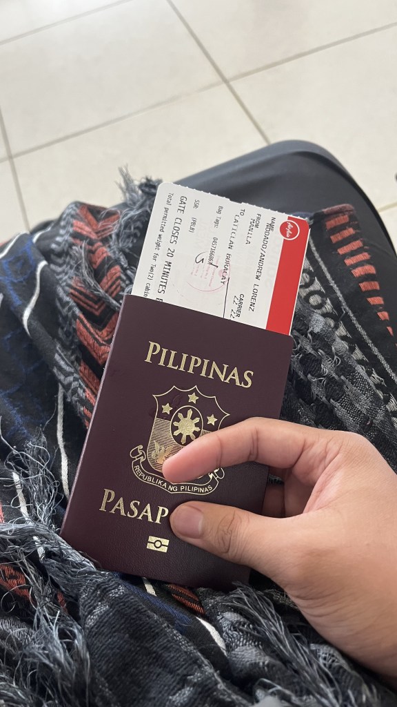 Photo of a passport with details of the flight attached inside. Photo taken from the airport while waiting for boarding.