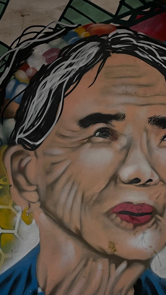 A vibrant mural of Apo Whang-Od, the legendary Kalinga tattoo artist, painted on a wall near Grace's house in Buscalan Village, Tinglayan, Kalinga, Philippines.