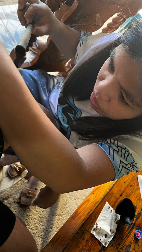 Maribel, a local Kalinga tattoo artist, performing a traditional batok tattoo using a bamboo stick and pomelo thorn in Buscalan Village.