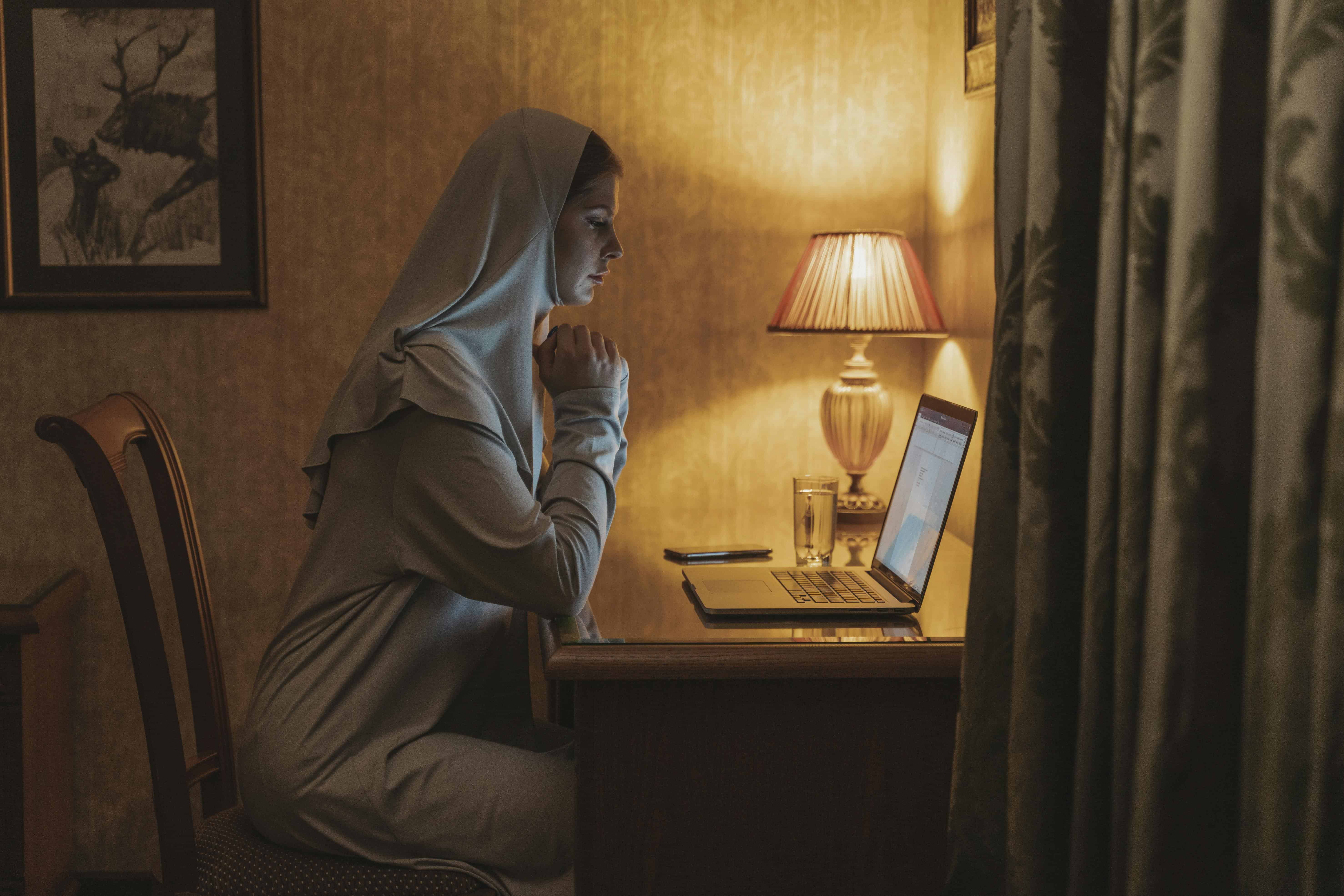 Person working from home at a desk in the evening, illustrating a focused work from home schedule layout